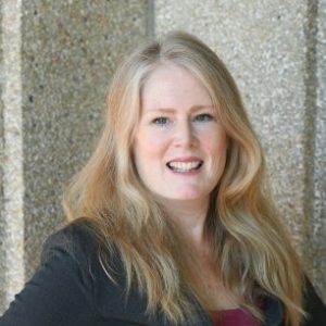 Head shot of Dr. Kathleen Gallagher in front of a stone wall facing the camera