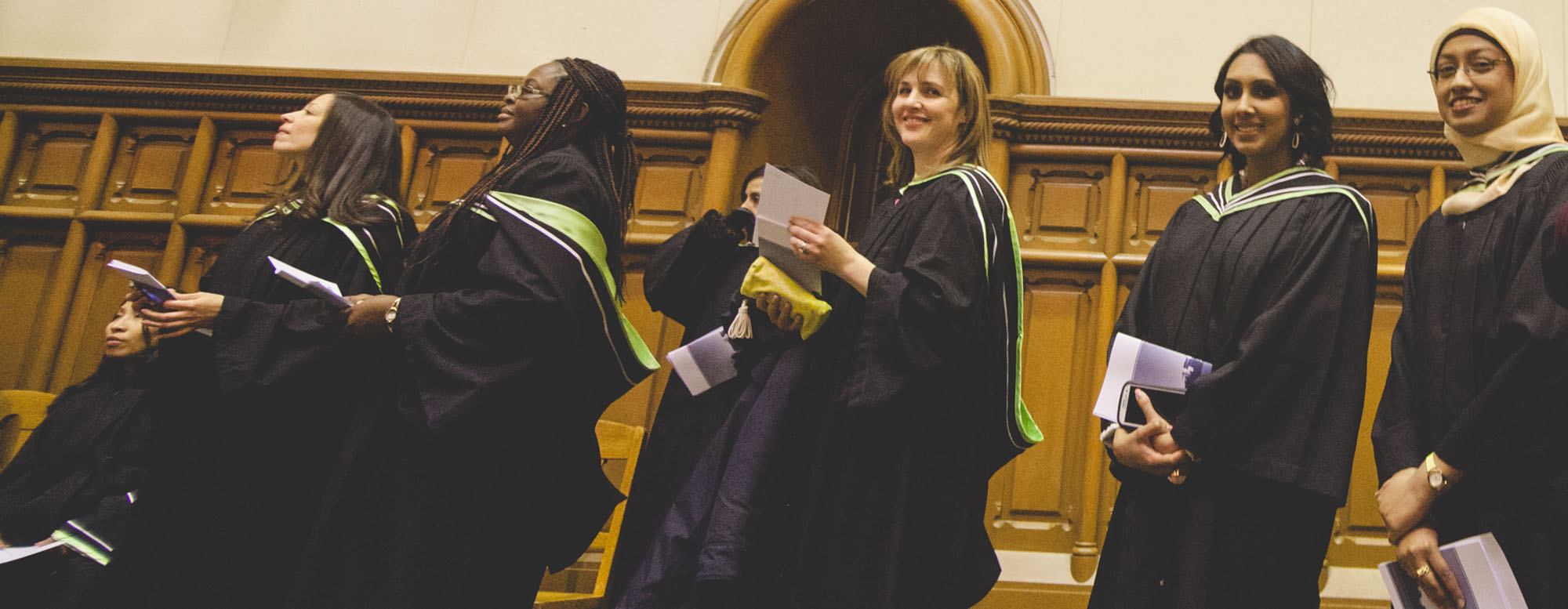 Students smiling and attending OISE convocation. 