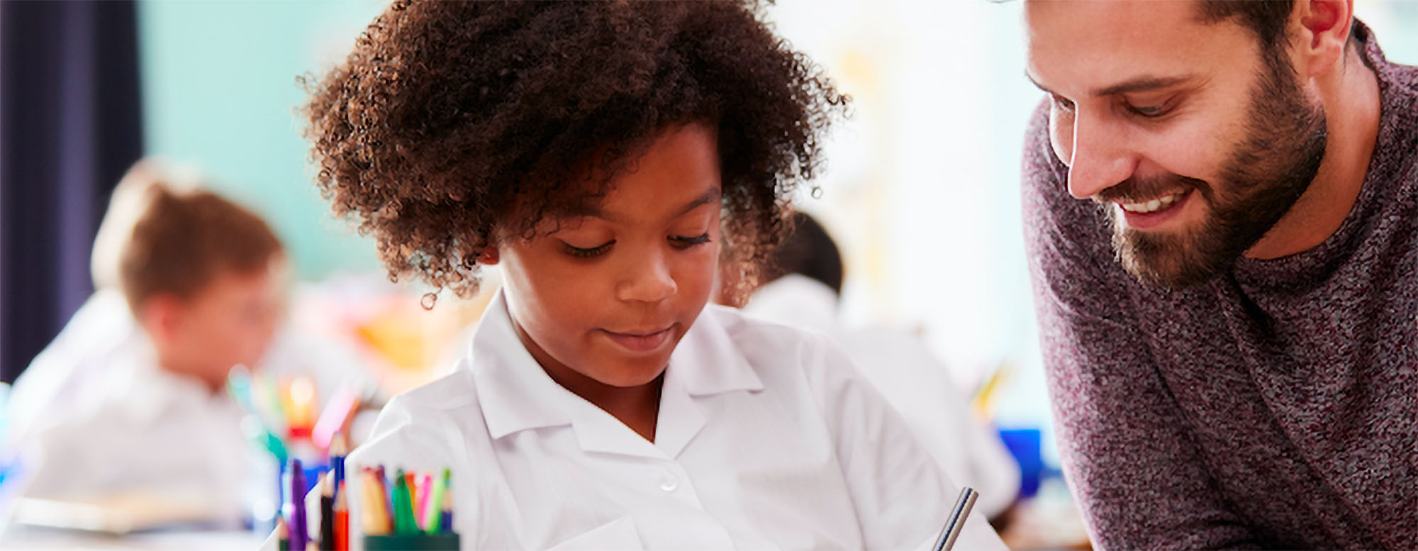 An educator working with a student on writing. 