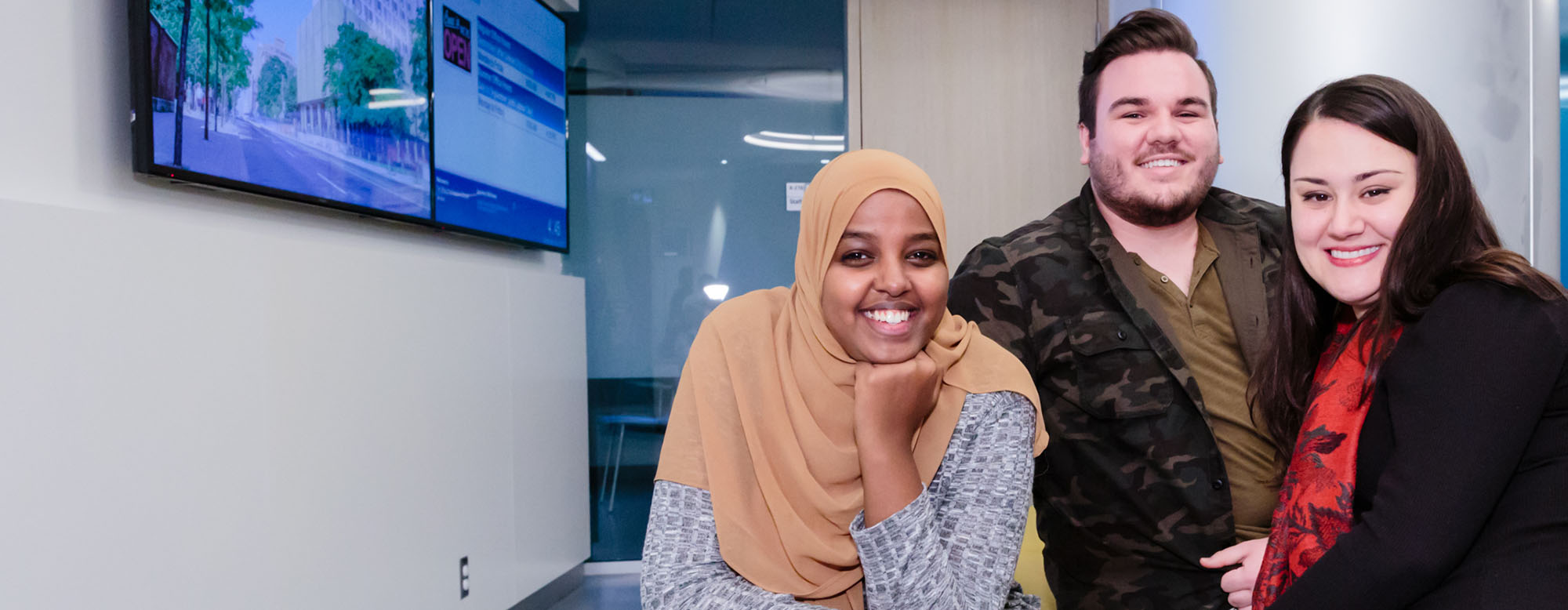 Three students sitting in the registrar's office lobby.