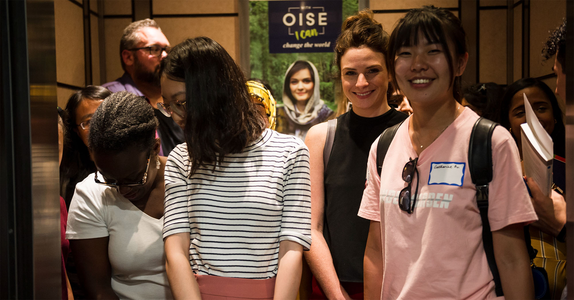 A group of students in an elevator at the OISE building.