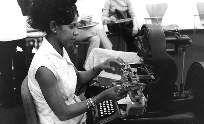 A woman using a typewriter at OISE - Archive photo.
