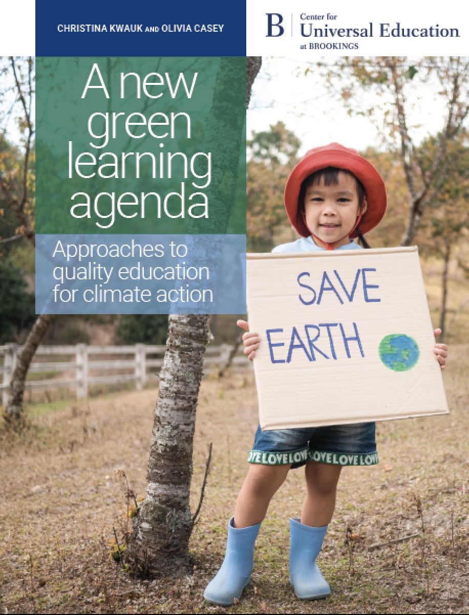 Child holding sign that reads save earth
