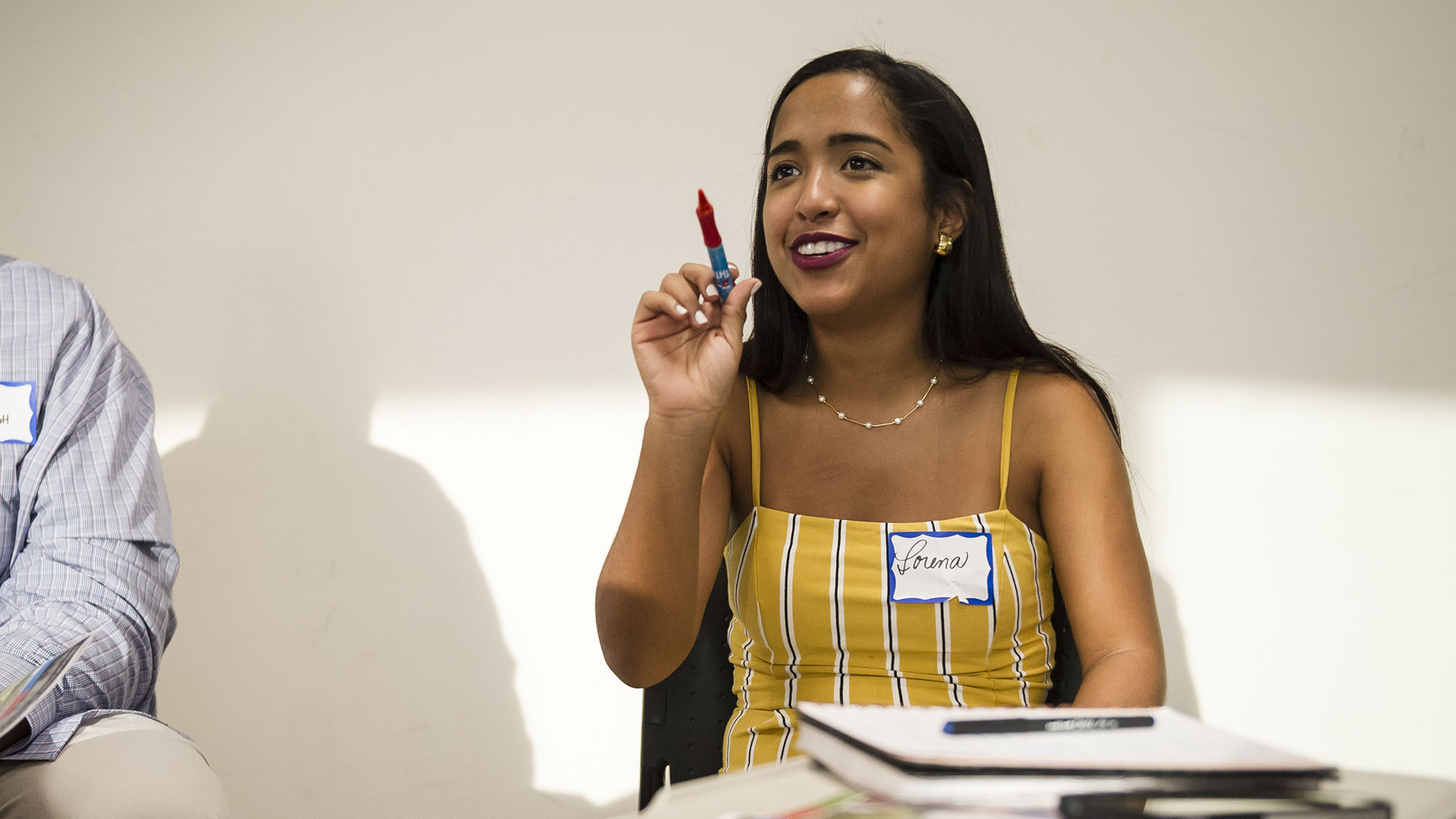 A student waving a pen, at orientation.