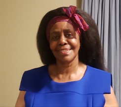 Woman with dark hair and a red headband, wearing a blue shirt