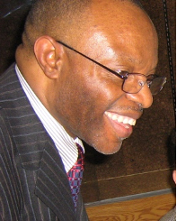Bald man in a suit and glasses smiling