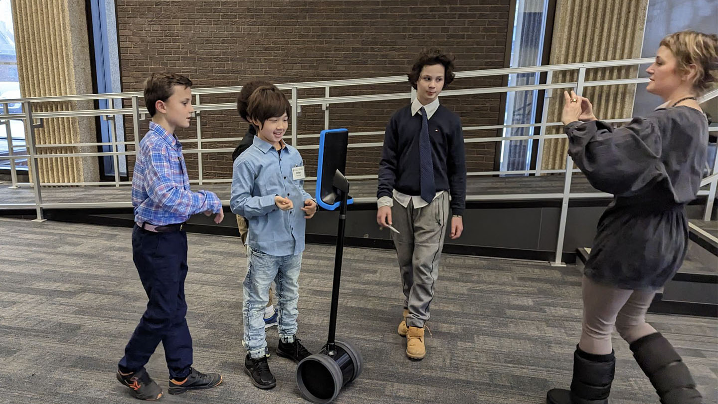 Four students and a Faculty member interacting with DAZEE the Robot at OISE.