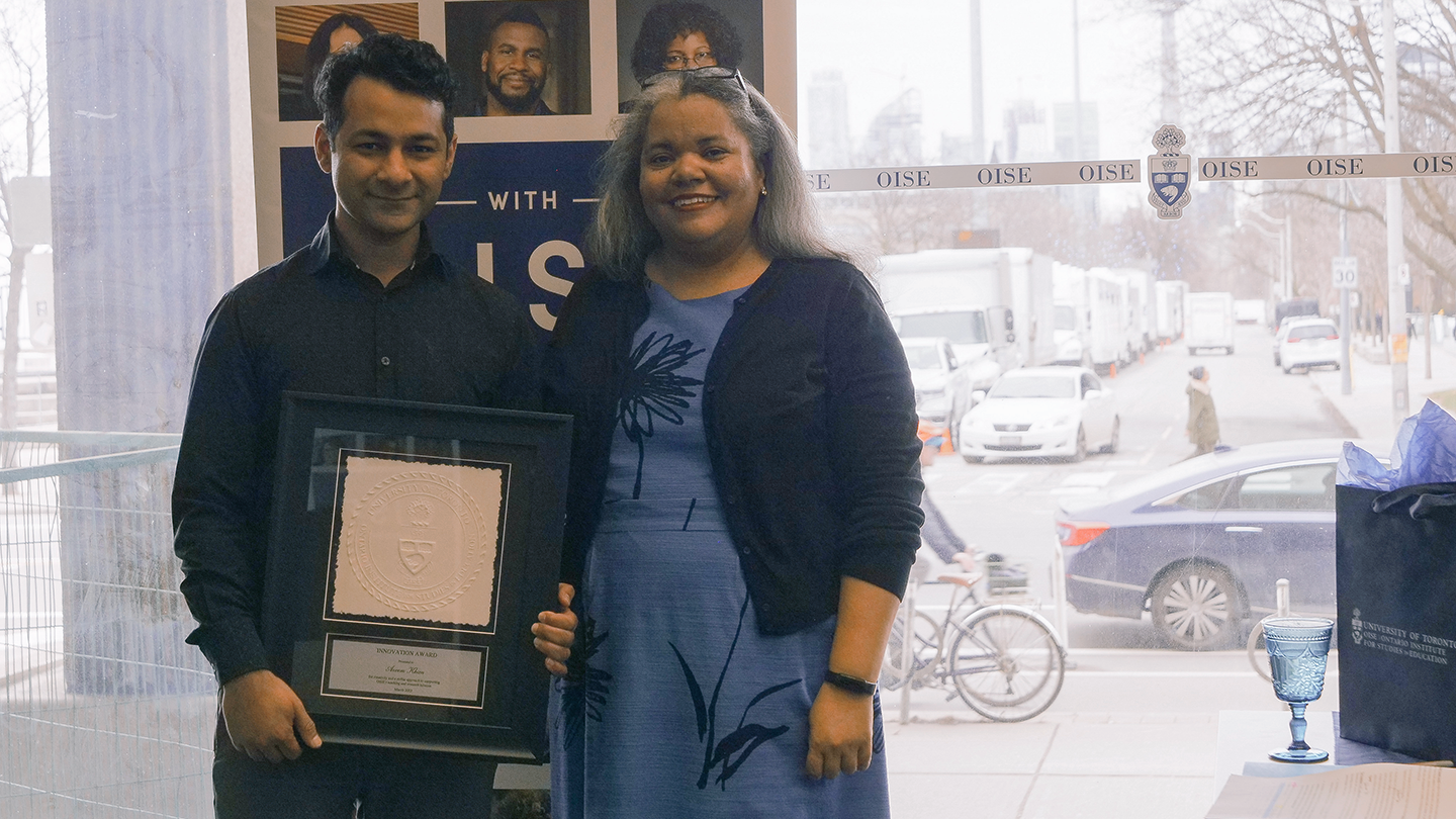 Education Commons' resident Audio Visual and Business Solution Architect, Azeem Khan, holds his Award plaque with OISE Dean, Professor Erica Walker.
