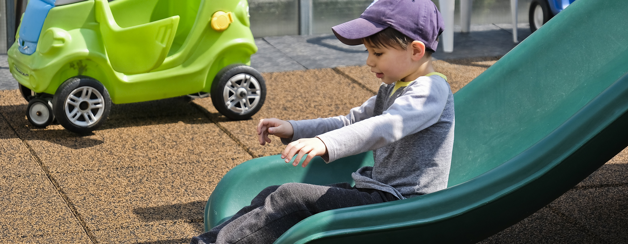 A child sliding down a slide in a playground.