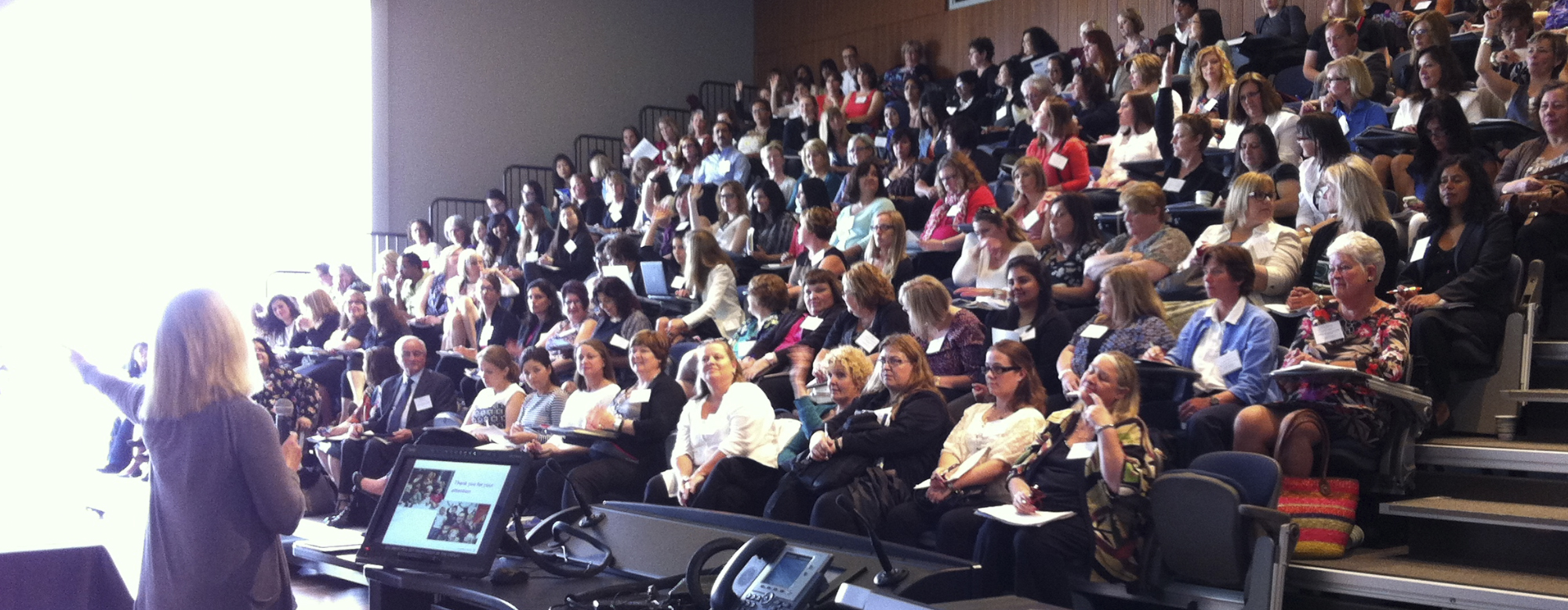 An individual presenting to a room full of individuals at the 11th Annual Summer Institute on Early Childhood Development.
