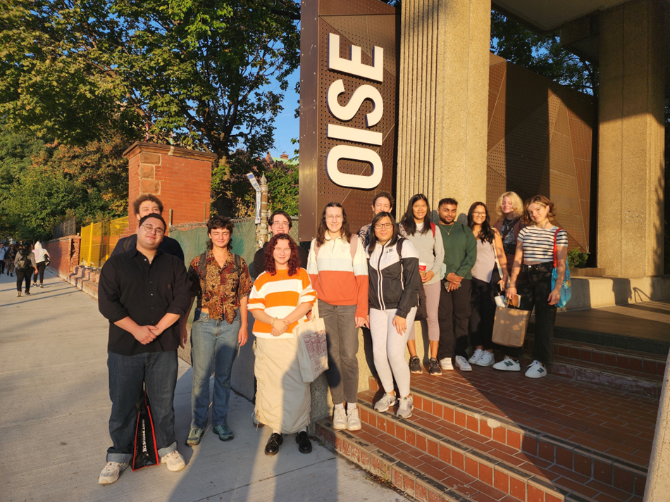 Students from the George Brown Chef School standing by the OISE sign