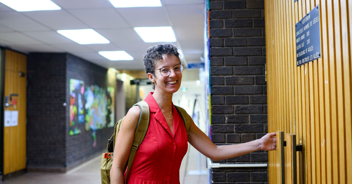 OISE student smiling while going into a classroom