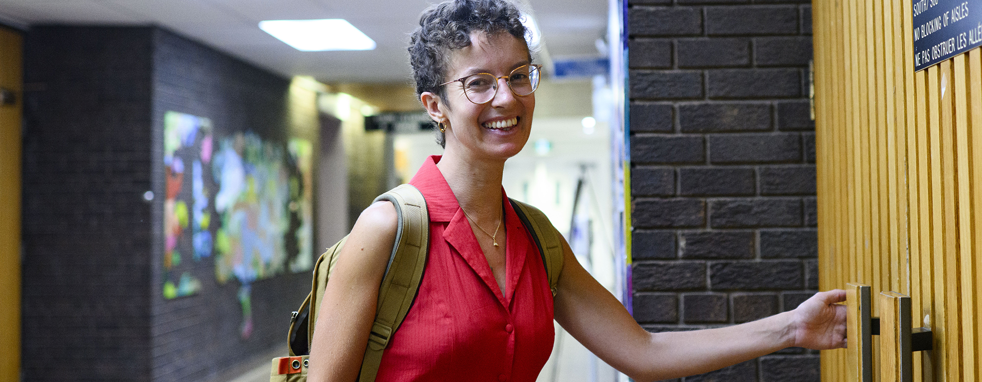 OISE student smiling while going into a classroom