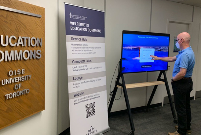 Demonstrating the touch screen at Education Commons