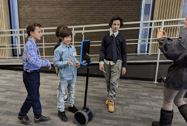 Four students and a Faculty member interacting with DAZEE the Robot at OISE.