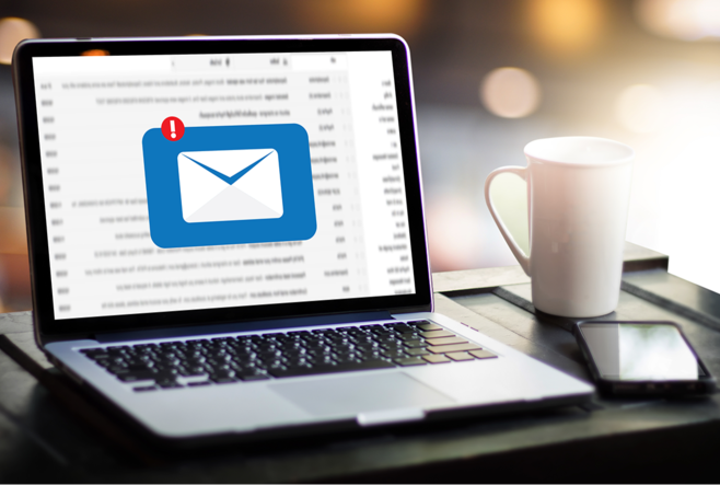 An open laptop on a desk, showing an email application. A pop-up is shown, a white envelope on a blue background, with a red ex