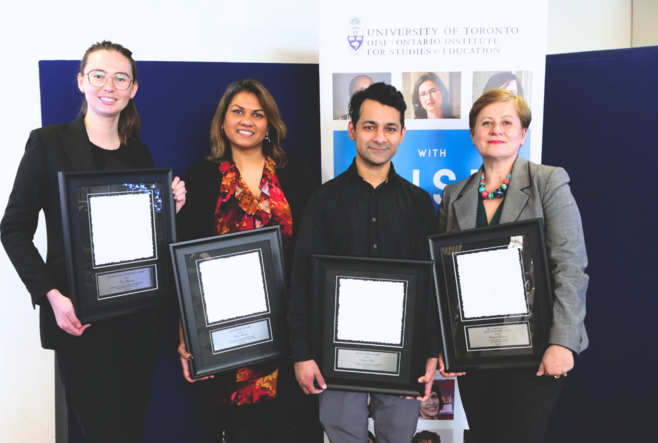 Four OISE staff members holding their awards