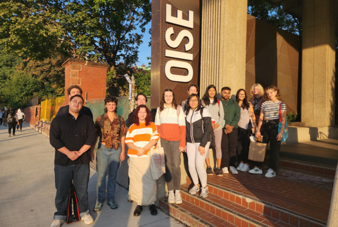 Students from the George Brown Chef School standing by the OISE sign