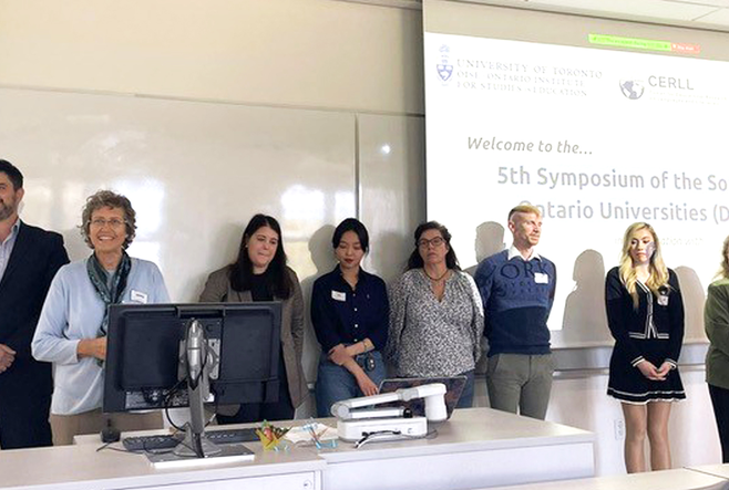 The symposium organizing committee standing at the front of a classroom