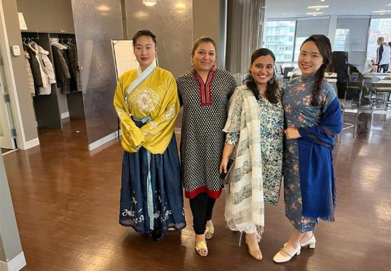 Four women standing in a hall dressed in cultural wear
