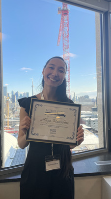 Aliya standing holding her plaque