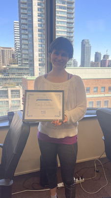 Emily standing holding her plaque