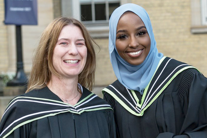 Two students smiling at OISE convocation.