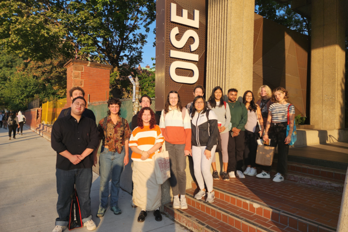 Students from the George Brown Chef School standing by the OISE sign