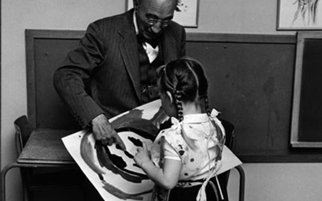 Dr. Blatz with child talking about her artwork.