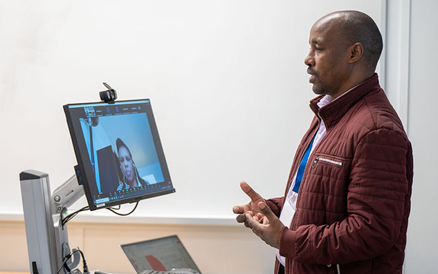 A presenter presenting and live streaming to Zoom.