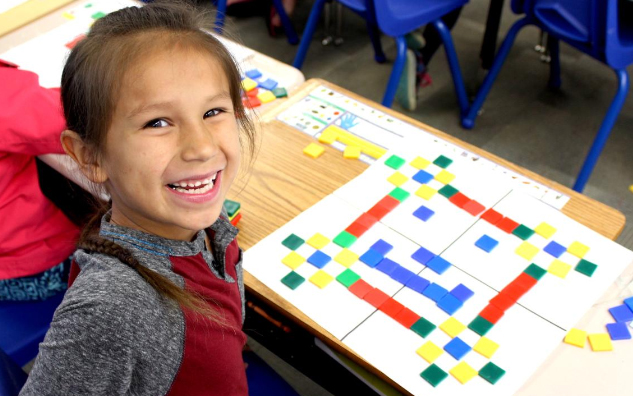 A child completing a colourful math activity.