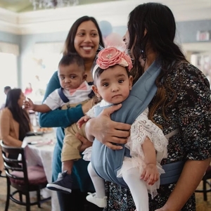 Shakina Rajendram, right, holds her daughter, Adiah, while her sister-in-law, Sharon Nadarajah, holds Adiah’s twin brother, Adrial, at the twins’ first birthday celebration.