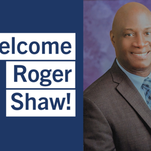 Headshot of Roger Shaw, who is smiling toward the camera. Roger is wearing a suit and tie. The words "Welcome Roger Shaw!" can be read to the left of Roger.