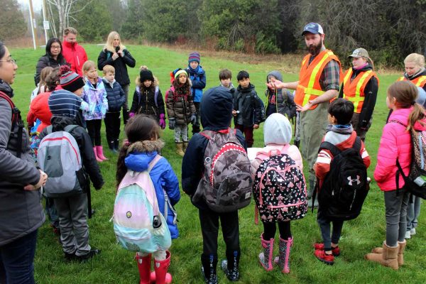 The class and visitors listen to Pete from Lake Ontario Atlantic Salmon Restoration