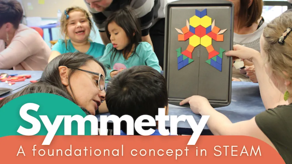 Children interacting in a classroom with a large title that reads, "Symmetry".