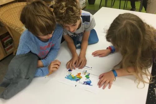 Three kids looking at thematic map