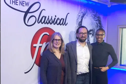 Dr. Kathleen Gallagher, Amaka Umeh and Marc Wigmore in front of a white wall with the Classical FM logo, for the radio show The Oasis
