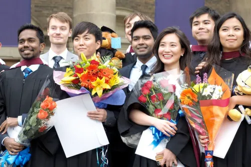 Graduates from the University of Toronto standing together in front of Convocation Hall