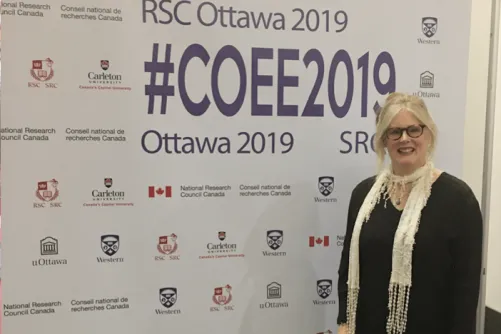Kathleen Gallagher standing in front of a Royal Society of Canada banner