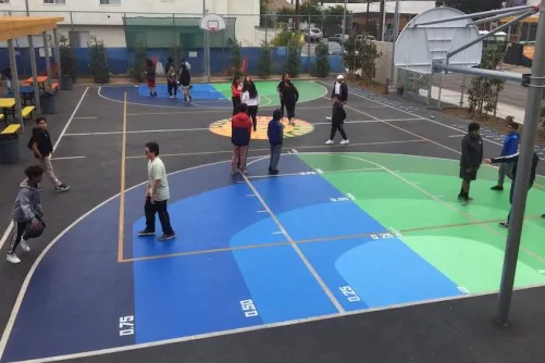 Children playing fraction ball on a basketball-like court.