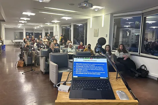 A view of the audience and a laptop at the 2024 Publishing Party.