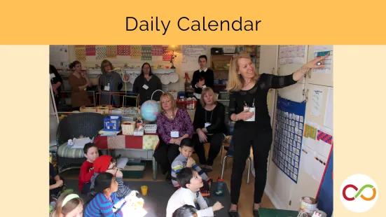A classroom with a bunch of people seated and an instructor standing and pointing at a calendar. A title reads, "Daily Calendar".