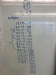 Multiples of 19 written on a whiteboard in blue marker.
