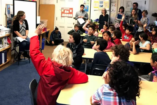Students raising their hand during a classroom discussion