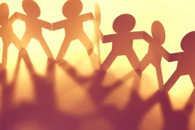 Paper cutouts of people holding hands.