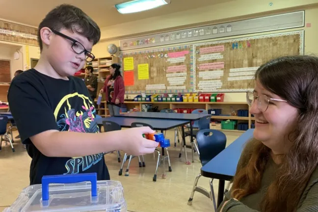 A student at Johnny Therriault School in Aroland First Nation plays with MA-CSE teacher candidate Natasha Dias.