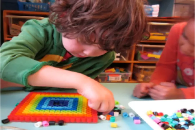 “It’s kind of a rainbow. Don’t you think it’s beautiful?” A junior kindergarten student creates rotational symmetry with pearler beads.