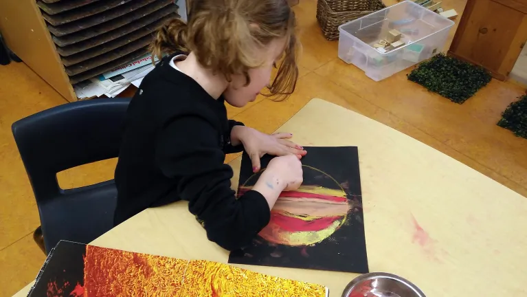 A student drawing in a classroom.