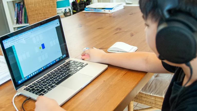 A student using a laptop and completing online math lessons.