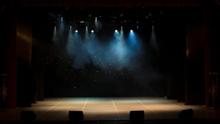 An empty stage of the theater lit by spotlights and smoke before the performance scaled